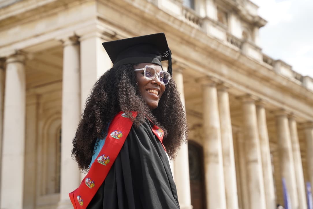 Shenita Rose in graduation cap and gown outside the Old Royal Naval College, Greenwich